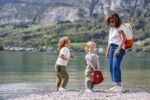 Une femme porte le sac à dos Neo Arcalod Nomad avec ses deux filles au bord du lac Annecy